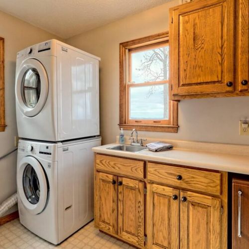 Laundry room with nice big stackable washer / dryer in the hallway