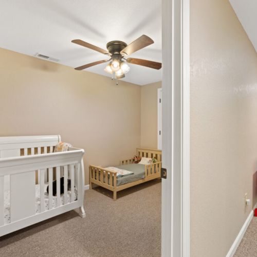 Basement level room with crib & child bed.