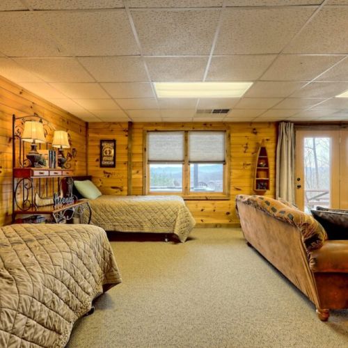 Downstairs lounge area with sleeping for 2, single beds. French doors lead to lower deck and hot tub.