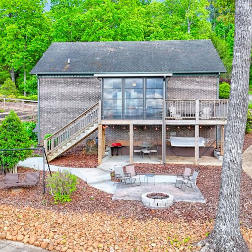 Rear view of property with screened porch and open deck. Notice the firepit and seating.