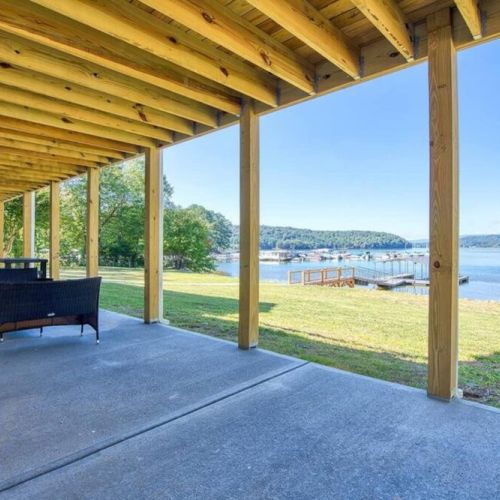 Outdoor lounging area on lower deck with views of the dock and lake.